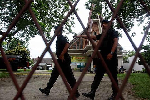 Indonesian policemen examine the Santo Yosef chuch after a man tried to attack a priest in Medan