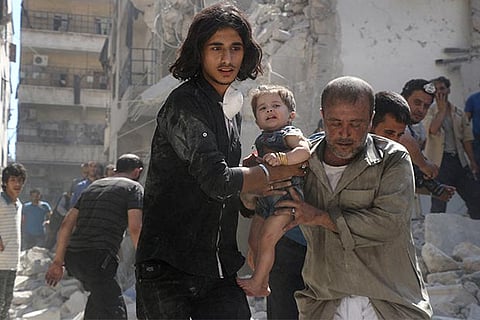 A Syrian civil defence member and a volunteer carry a little girl rescued from under the rubble