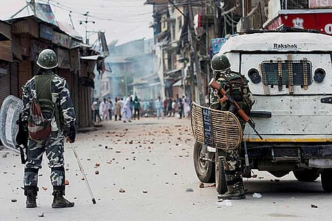 Security forces personnel on guard during a clash with the protesters