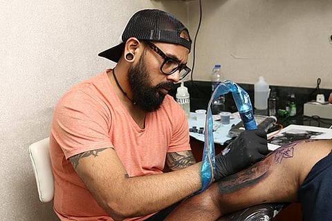 Sameer Patange works on a tattoo of a client in Chennai (Photo: Manivasagan N)