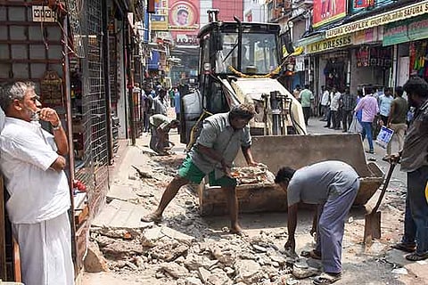 Corporation workers clearing encroachments and extension structures in front of shops