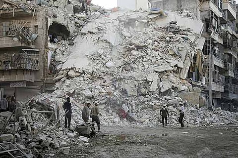 Syrian Civil Defence search for victims amid the rubble following reported air strikes at Qatarji