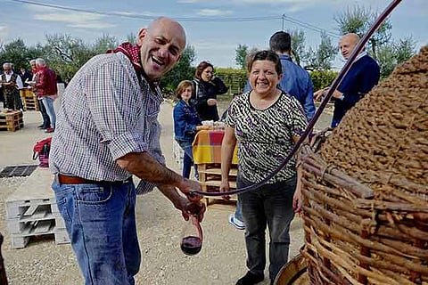 Visitors drinking wine from a fountain in Caldari di Ortona, Italy