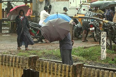 People go about their work in the rain at Nagapattinam