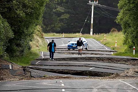 Residents look at damage caused by an earthquake