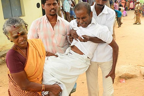An old man being assisted to reach a polling booth in Tiruparankundram