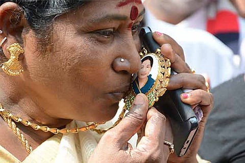 AIADMK woman kisses the image of CM Jayalalithaa