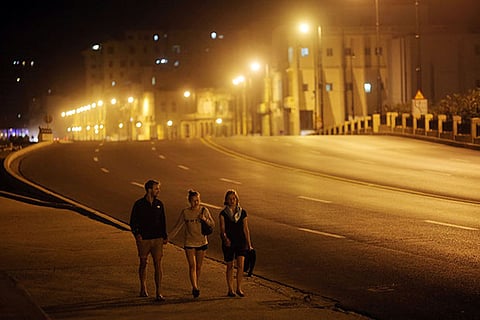 Tourists walk along the Malecon in Havana