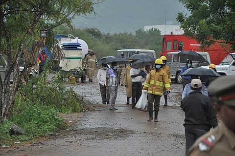 Fire personnel coming out with mutilated body parts in bags from the factory premises