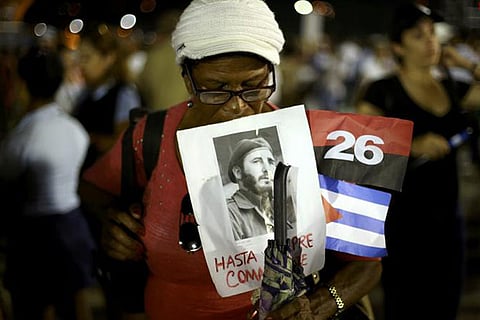 A woman holds an image of former Cuban leader Fidel Castro at a tribute to the revolutionary leader