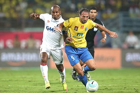 Delhi Dynamos captain Florent Malouda (left) vies for the ball with Kerala Blasters? Cedric Hengbart