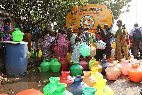 Women queueing up to get water from a tanker, in the city