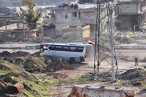 A bus drives through Syrian government-controlled crossing of Ramoussa, on the outskirt of Aleppo