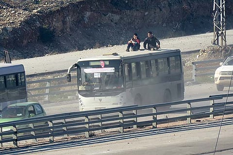 A bus drives as a convoy of four buses, with on board people who are evacuated from Fuaa and Kafraya