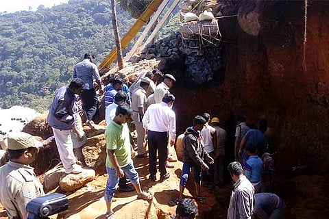 Fire and Rescue Services personnel engaged in retrieving the bodies of buried workers in a landslip
