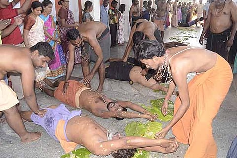 Ayyappa devotees roll over plantain leaves after an Annadhanam in Kovilpatti