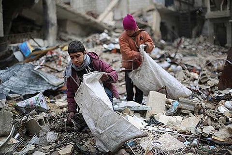 Syrian youths collect wood from rubble to be used for heating and cooking
