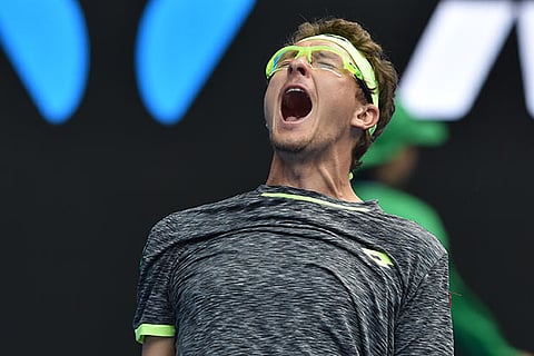 Denis Istomin celebrates after beating Novak Djokovic