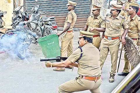 An officer lobbing tear gas at arsonists