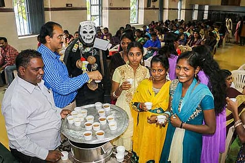 GCC officials distribute a medicinal drink as part of dengue awareness to students