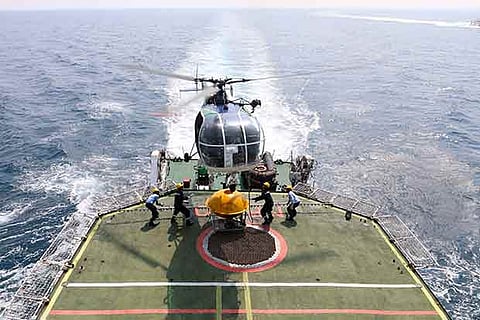 A helicopter takes off from the launch pad on the ICGS Varad to conduct a sortie