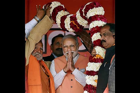 Narendra Modi being garlanded at an election campaign rally at Barabanki district