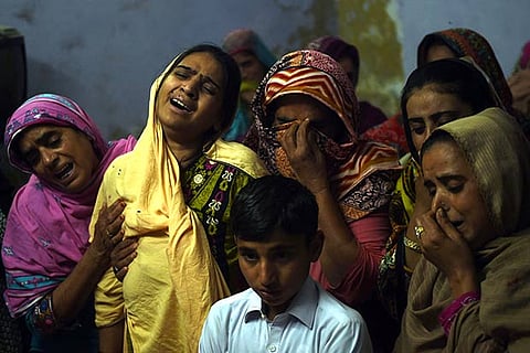 A Pakistani mother (2L) mourns along with others over the coffin of her son