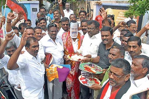 DMK cadre present a protester with MLA Pollachi V Jayaraman?s mask a cosmetics kit