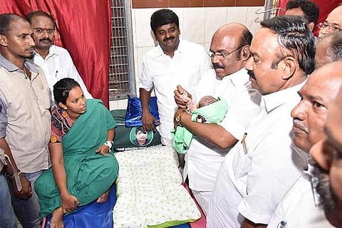 Minister D Jayakumar presents a gold ring to a child born on Jayalalithaa birth anniversary