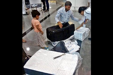 Customs personnel taking stock of the imported cigarettes that were seized from passengers
