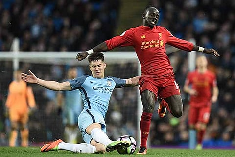 Sadio Mane (right) is tackled by Manchester City?s English defender John Stones (left)