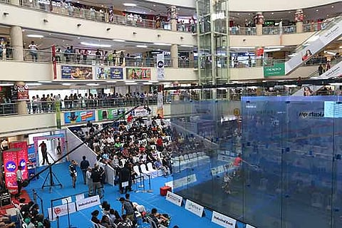 Spectators watch a game of squash at the Express Avenue Mall