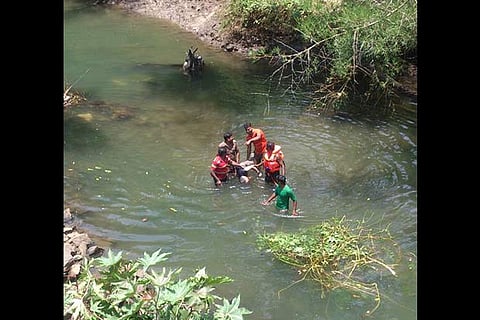 Fire and rescue services personnel retrieving the body of one of the victims from the river