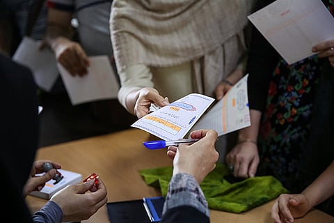 Voters receive ballot papers during the presidential election in a Jewish and Christian district