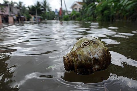 A doll head floats in floodwaters in Dodangoda village in Kalutara
