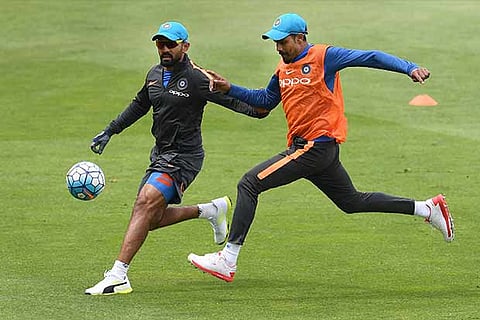 India?s Dinesh Karthik and Ravindra Jadeja play a game of football ahead of a training session