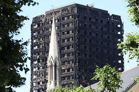 A church spire stands in the foreground of Grenfell Tower in North Kensington, London