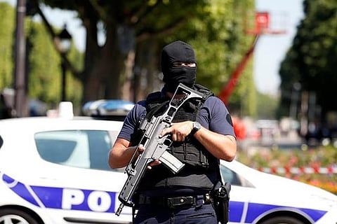 A masked French policeman secures the area on the Champs Elysees avenue