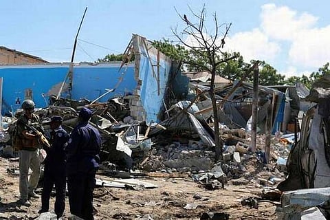 A foreign security officer stands with Somali policemen