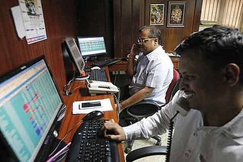 Brokers trade at their computer terminals at a stock brokerage firm in Mumbai.