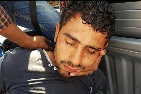 A security personnel detains the accused who stabbed two German tourists to death (Reuters)