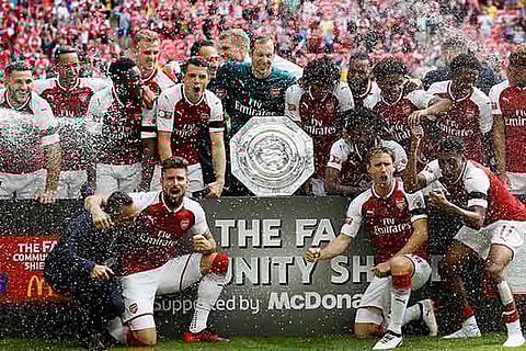 Arsenal players pose with the trophy after winning the English Community Shield against Chelsea