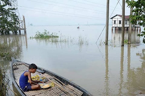 A child having his meal on a boat at a flood affected village in Morigaon district of Assam.(PTI)