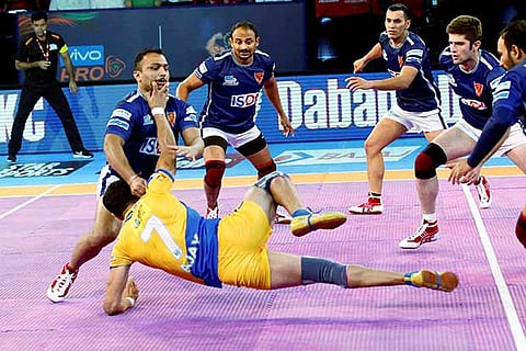 Dabang Delhi players catch a player of Tamil Talaivas in a pro Kabaddi league match in Ahmedabad
