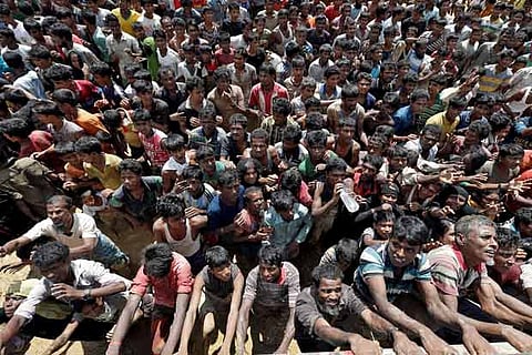 Rohingya refugees react as aid is distributed in Cox's Bazar, Bangladesh