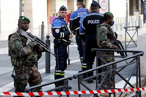 French police secure a street after they shot and killed a man who stabbed two women to death