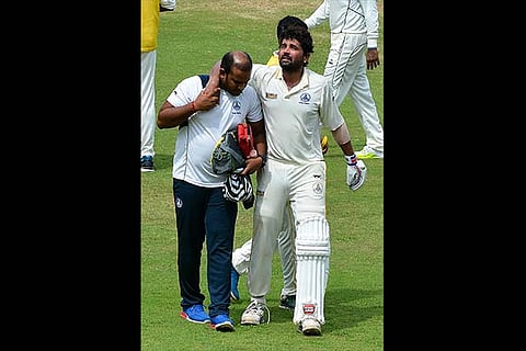 Murali Vijay (right) limps off after twisting his ankle