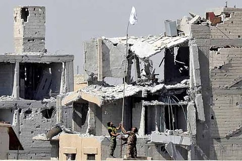 Fighters of Syrian Democratic Forces raise a white flag