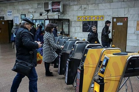 Passengers are seen passing through turnstiles to ride the subway system in Kiev, Ukraine