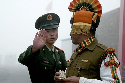 File photo of a Chinese soldier gestures as he stands near an Indian soldier at the Nathu La border